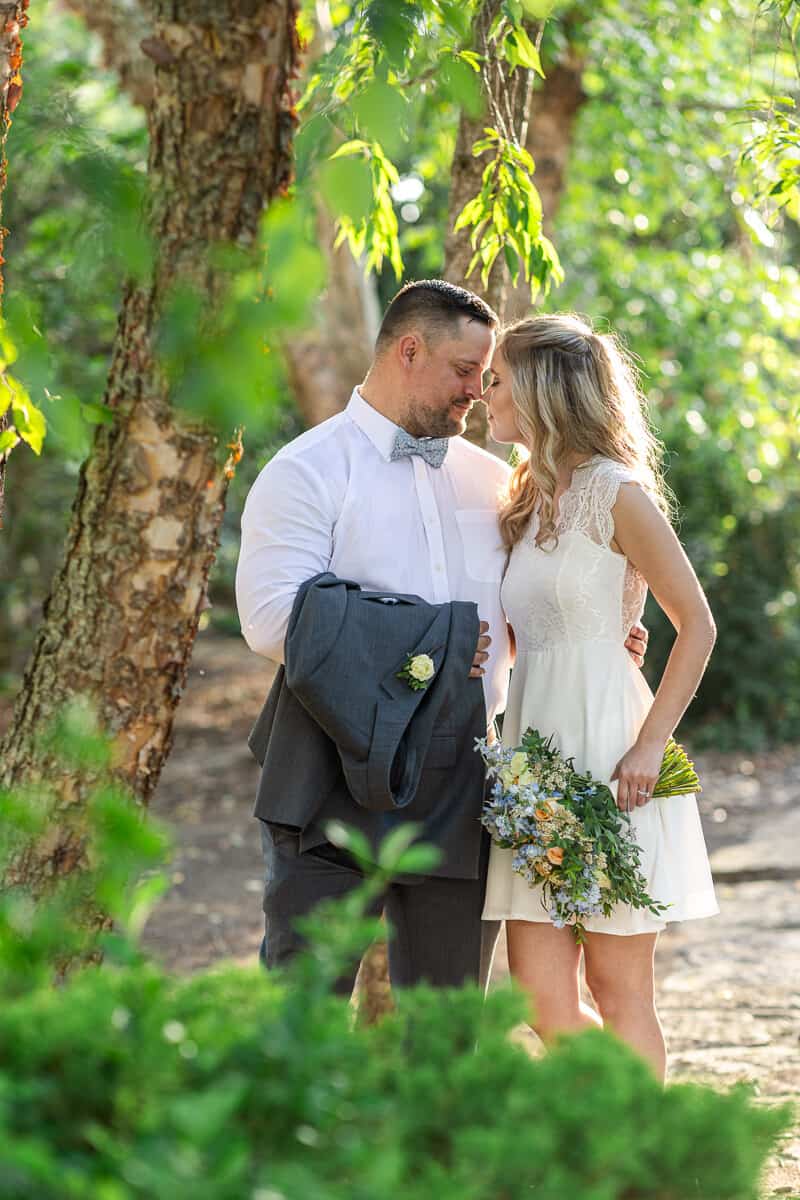 Bride and groom touch foreheads in sunset glow